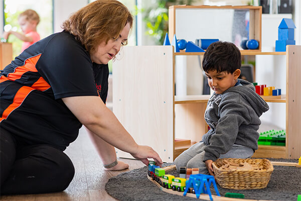 SK-Section-Educators2 Sunkids educator playing with a child and train set